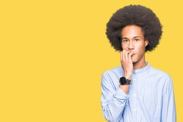 Fototapeta na wymiar Young african american man with afro hair looking stressed and nervous with hands on mouth biting nails. Anxiety problem.