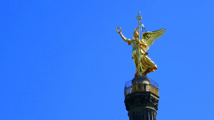 leuchtend goldene Siegesgöttin auf der Siegessäule in Berlin vor stahlblauem Himmel
