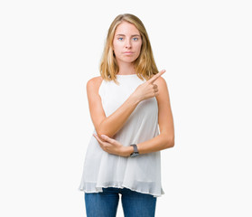 Beautiful young elegant woman over isolated background Pointing with hand finger to the side showing advertisement, serious and calm face