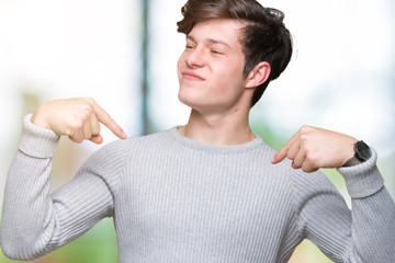 Young handsome man wearing winter sweater over isolated background looking confident with smile on...