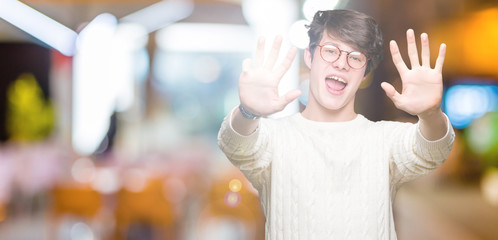 Young handsome man wearing glasses over isolated background showing and pointing up with fingers...