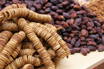 Big dried dates and dried figs strung on twine, lying on a large counter at the market in Deira, Dubai