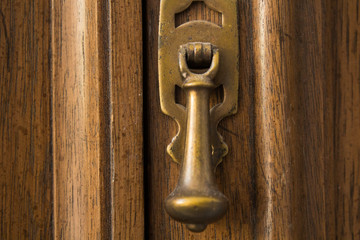 Brass handle closeup in wooden frame on cabinet door
