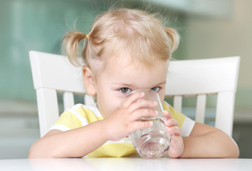 Child girl drinking water from glass closeup portrait.