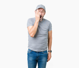 Handsome middle age hoary senior man wearing sport cap over isolated background covering one eye with hand with confident smile on face and surprise emotion.