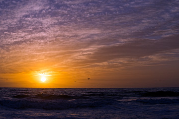 Fototapeta na wymiar Sunset over Ocean with Clouds