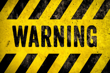 WARNING danger sign word text as stencil with yellow and black stripes painted over concrete wall cement texture background. Concept image for caution, dangerous area and hazard.