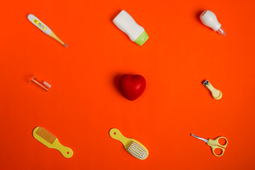 Healthcare accessories for newborn on red background, flat lay