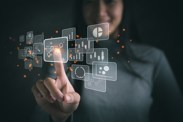 Big data analytics and business intelligence concept with chart and graph icons on a digital screen interface and a businesswoman in background