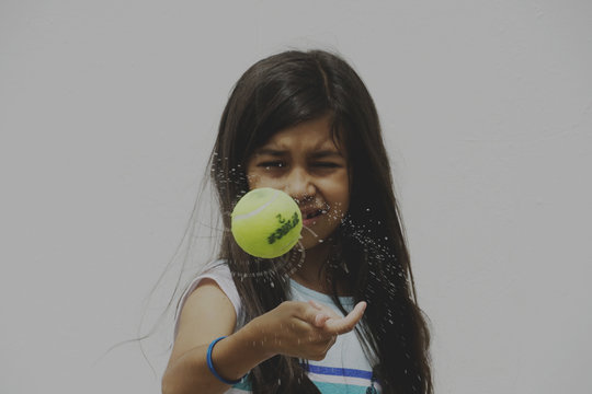 little girl spinning a wet ball