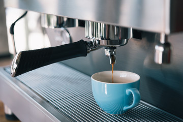 Espresso machine making coffee with blue cup in pub, bar, restaurant
