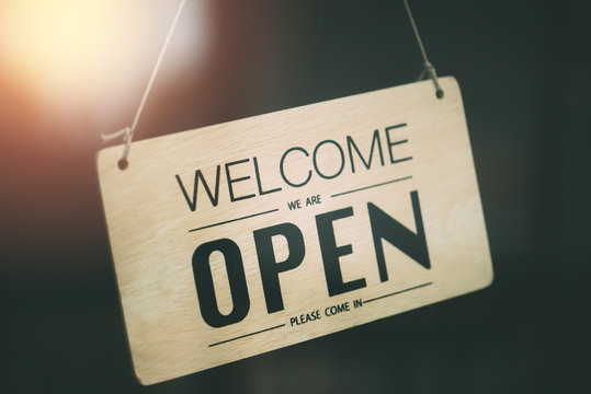 "Open" on cafe or restaurant hang on door at entrance.
