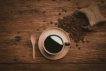 Coffee cup and beans on old wood table. Top view with copyspace for your text