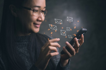 woman sending e-mail message to mailing list contacts using smartphone,