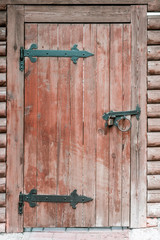 Historic traditional wooden door with metal hinges as part of wooden fence