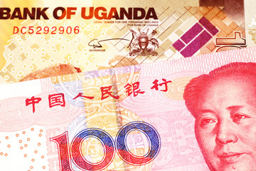 A red one hundred yuan bill from China with a one thousand Ugandan shilling bill close up in macro