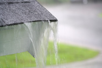 close up on rain flowing from old roof