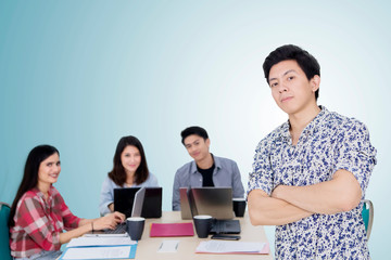 Confident male entrepreneur stands with his team