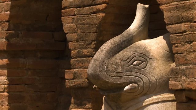 An extreme close up of the sideview of the statue elephant built under an arch in a building