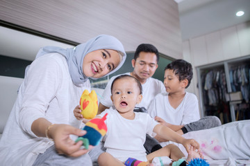 Muslim family enjoying leisure time on the bed