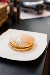 three pancakes with banana in white dish