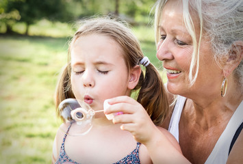 Grandmother and child blowing bubbles