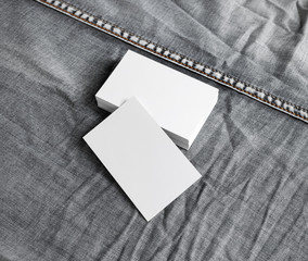 Blank business cards on gray denim background.