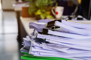 Stacks of piles unfinished papers documents files in accounting business report with black clips paper corner on desk in busy office, Paperwork of financial folder at business workplace concept