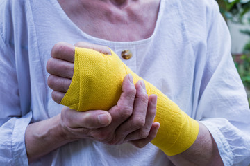 A woman wears a bandage around her wounded arm. Concept health.
