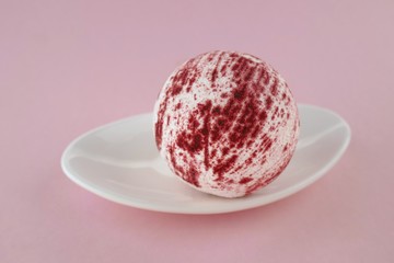 bath bomb.Pink Striped Bomb Bath on a white dish on a  pink pastel background.Organic body cosmetics