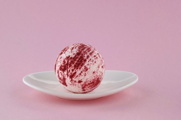 bath bomb.Pink Striped Bomb Bath on a white dish on a light pink pastel background.Organic body...