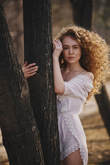 Curly beautiful girl, portrait on the street, autumn yellow leaves.