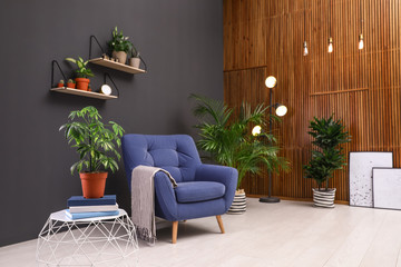 Room interior with armchair and indoor plants. Trendy home decor