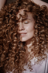 Curly beautiful girl, portrait on the street, autumn yellow leaves.