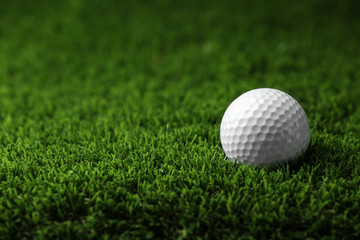 Golf ball on artificial grass, space for text