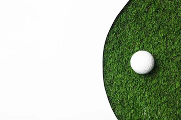 Rolgordijnen Golf ball and white paper on green artificial grass, top view with space for text © New Africa