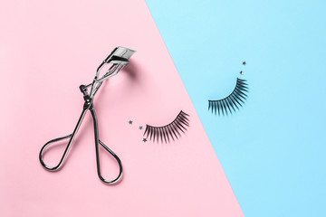 False eyelashes and curler on color background, flat lay