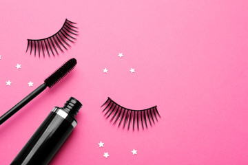 False eyelashes and mascara on pink background, flat lay. Space for text