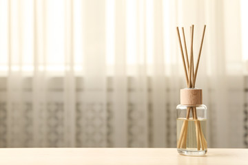 Reed air freshener on table indoors, space for text