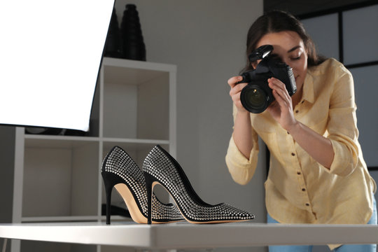 Professional photographer shooting stylish shoes in studio
