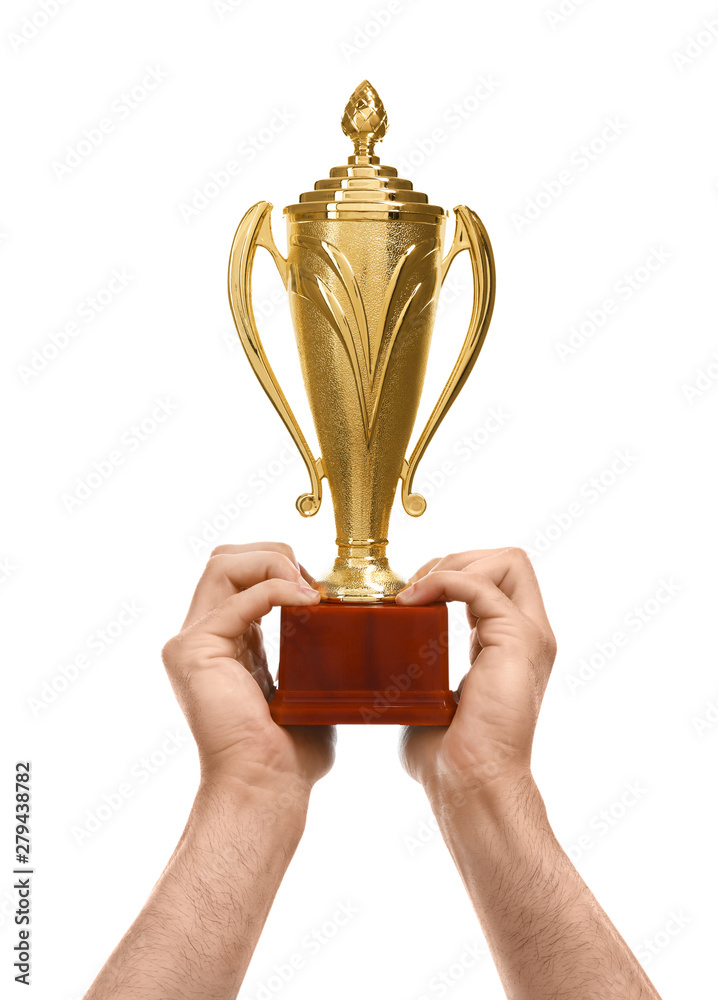 Wall mural Young man holding gold trophy cup on white background, closeup