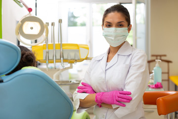 Serious middle-aged female doctor in a green mask