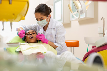 Concentrated serious middle-aged female doctor holding dental instruments