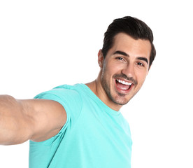 Happy young man taking selfie on white background