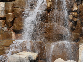 Close up of water cascading down rocks in a garden waterfalls