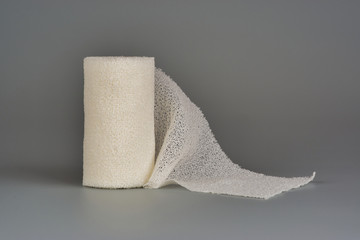 Elastic bandage for dressing wounds, on a gray background.