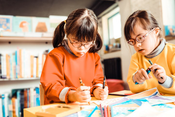 Resolute girls with problems in mental health being interested in painting
