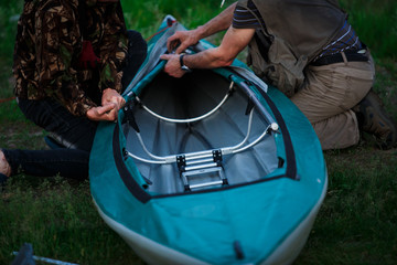 The process of assembling and repairing kayaks: metal skeleton, PVC skin, wooden and aluminum frames. Male hands assemble the canoes and paddle boating.