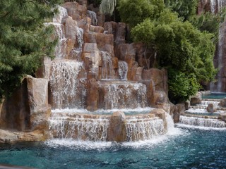 Fototapeta na wymiar Man-made waterfalls in a landscaped garden