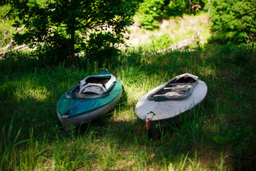 Two kayaks lie on the shore with oars. Preparing for water campaign, assembling kayak
